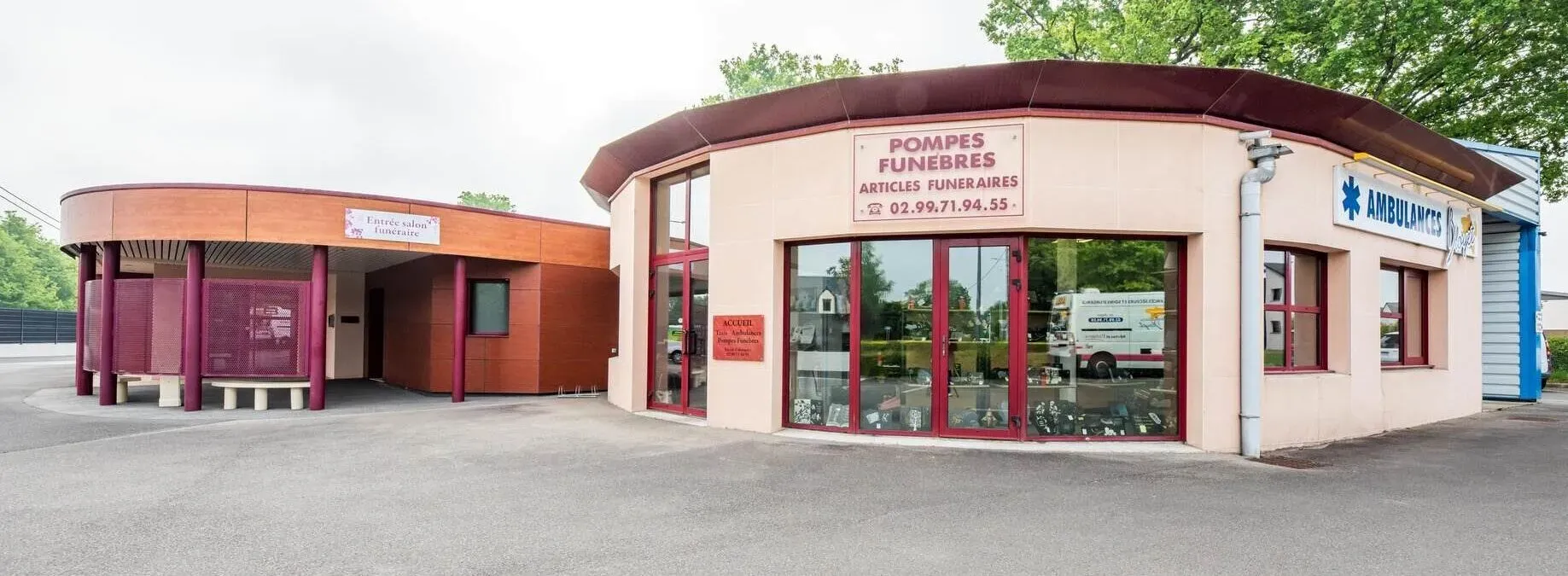 Bâtiment de pompes funèbres et salon funéraire avec grandes baies vitrées.