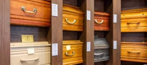 Modèles de cercueils en bois présentés sur des étagères dans un magasin funéraire.